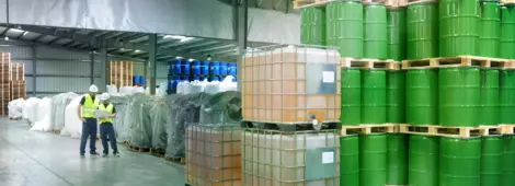 group of workers in the logistics industry work in a warehouse with chemicals