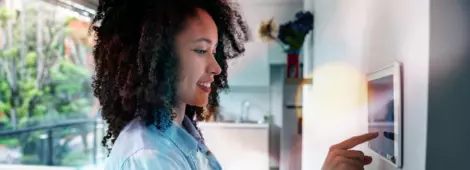 woman setting up the intelligent home system on a tablet computer - technology concepts