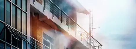 The smoke coming out of the front of the high building due to a fire.