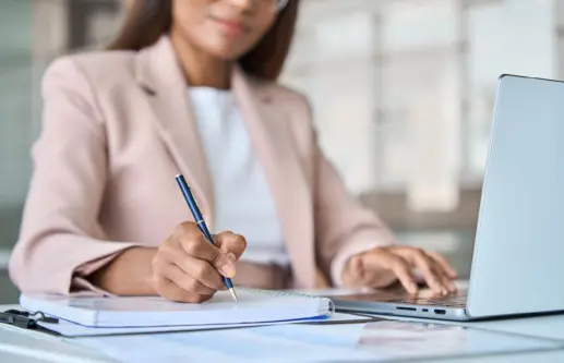Close up view of professional business woman working writing notes in notebook