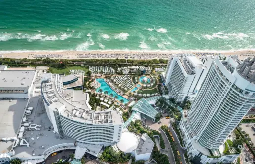 aerial view of hotel building, pools and ocean