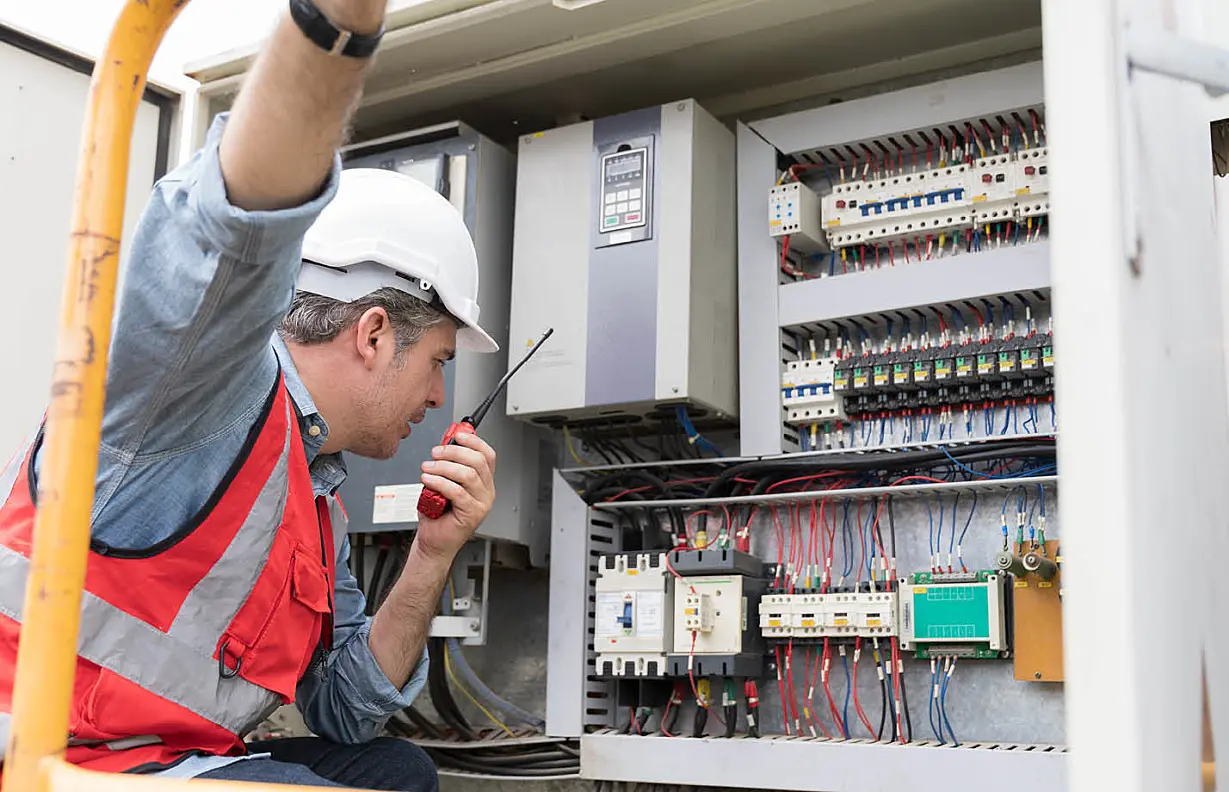 Male electrician checking, repair, maintenance operation electric system in crane construction site