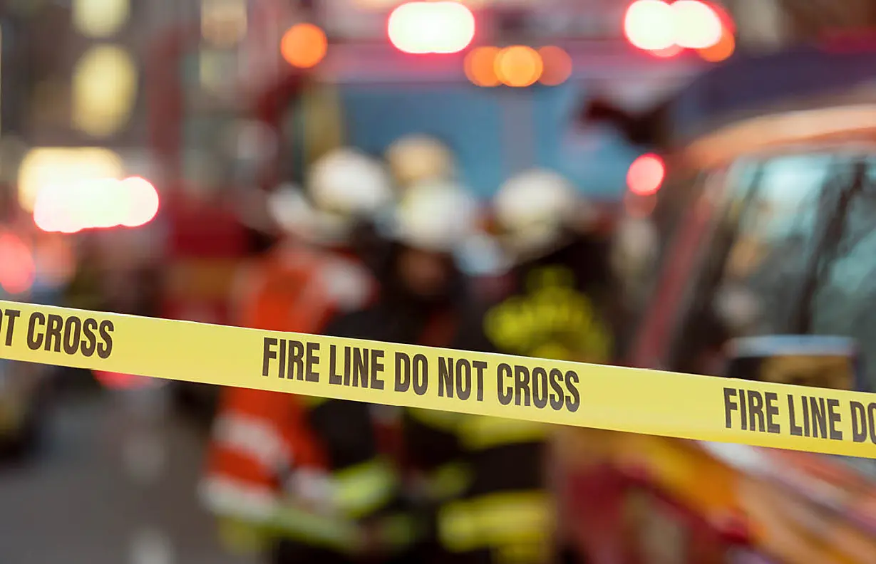 A fire line and fire department vehicle. - fire line do not cross on yellow tape