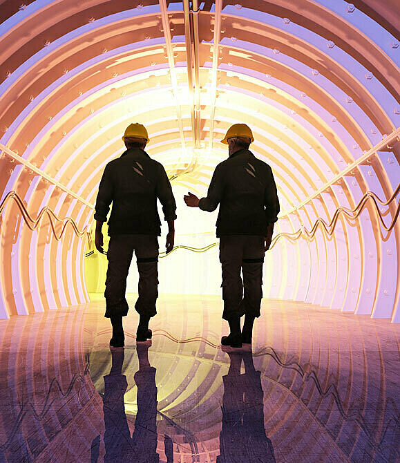 Two workers walking through tunnel