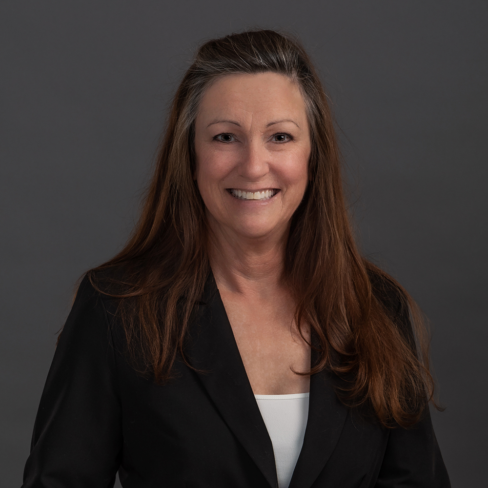 Professional business headshot of a woman in a white blouse