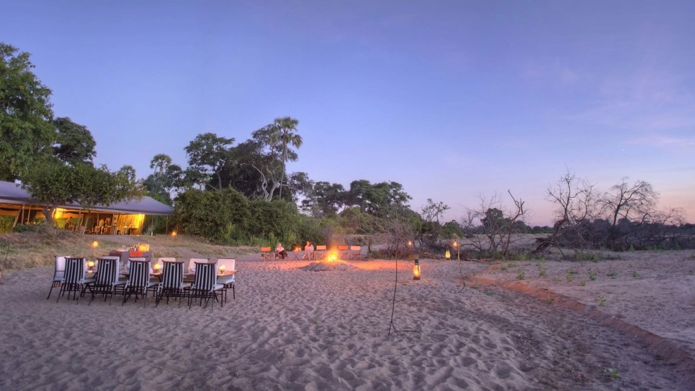 Asilia kwihala camp sundowners and dinner set up around the fire 2400
