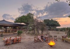 Asilia roho ya selous guests enjoying sundowners by the fire 1280