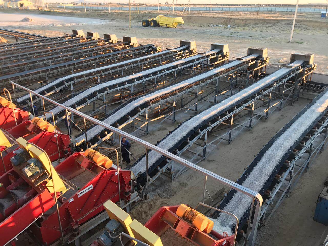 A row of Dewatering Screens discharging salt to conveyors.