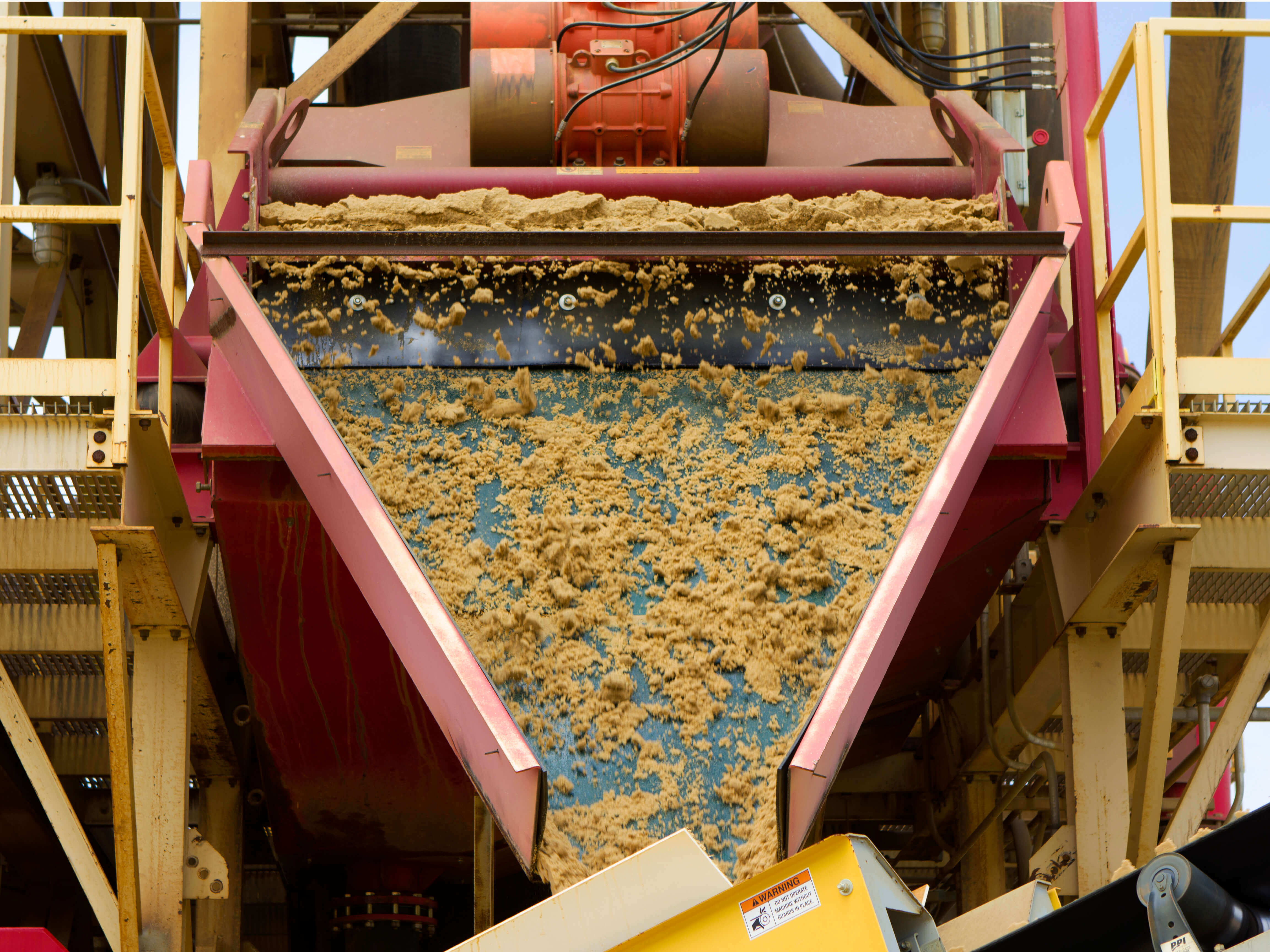 Front view of a Dewatering Screen discharge chute with sand.