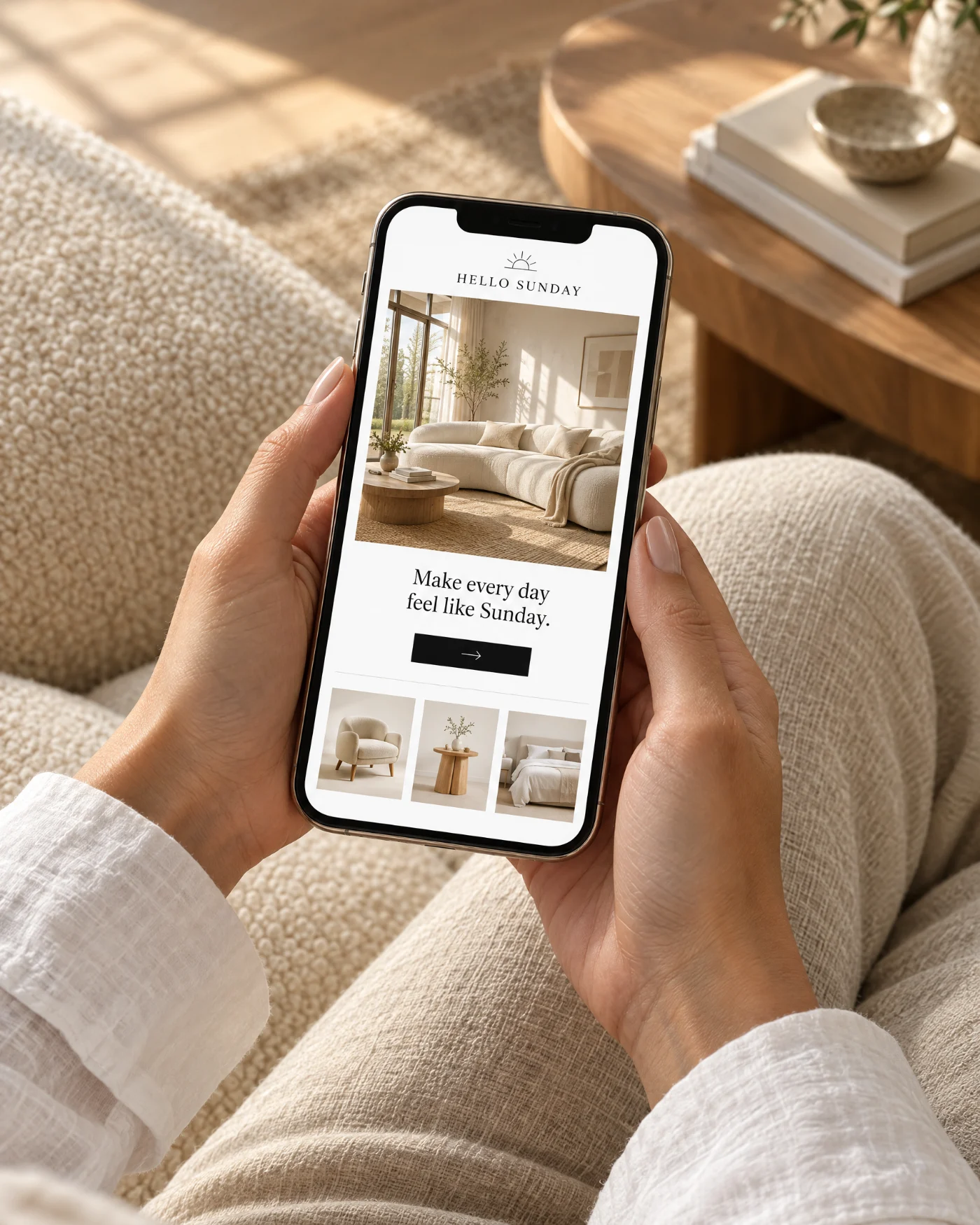 The HELLO SUNDAY app open on a phone, held over a cream sofa