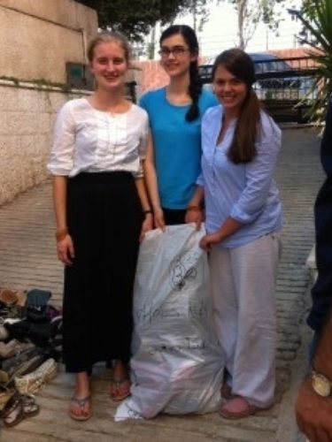 NSLI Y students posing with the clothes they sorted