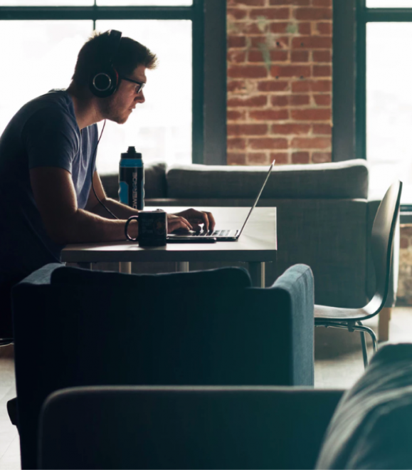 Man on computer in open room