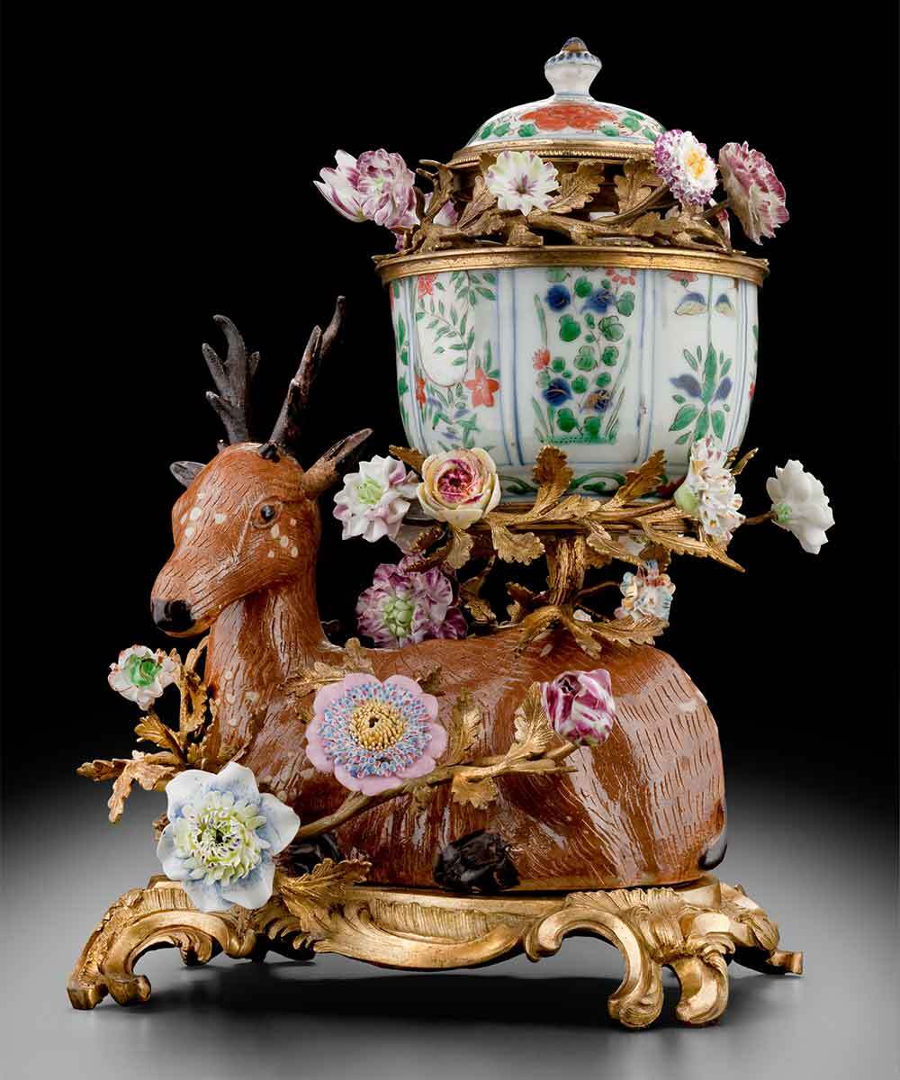 An 18th-century potpourri vase shaped like a deer, decorated with porcelain flowers and branches.