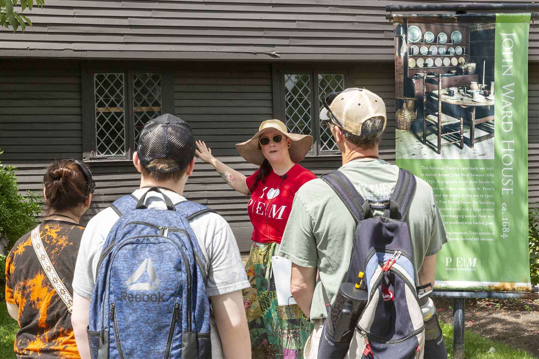 Visitors listen to the tour guide as they all stand in front of the John Ward house