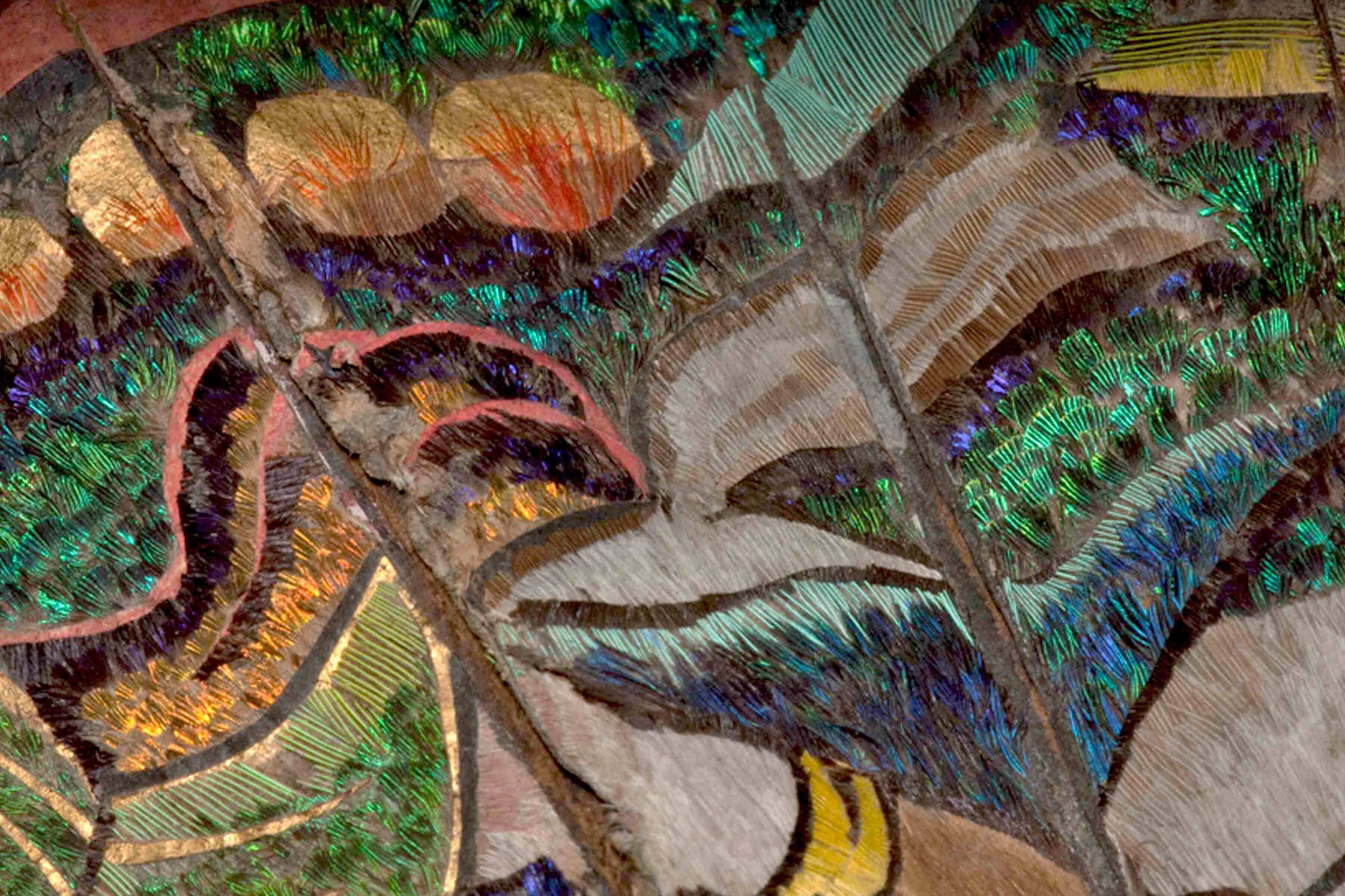 Close up detail of A folding fan comprised of pierced hawksbill tortoise shell, painted paper and feathers