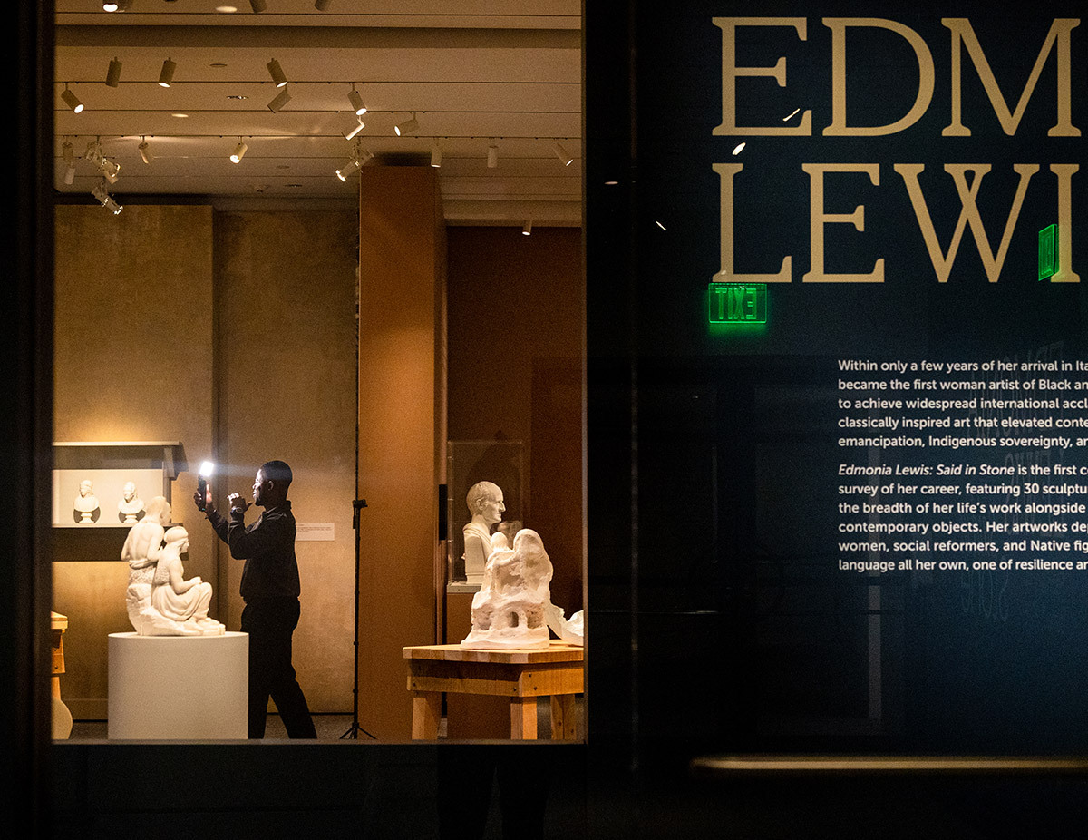 An influencer capturing video in the gallery for the opening of Edmonia Lewis: Said in Stone.