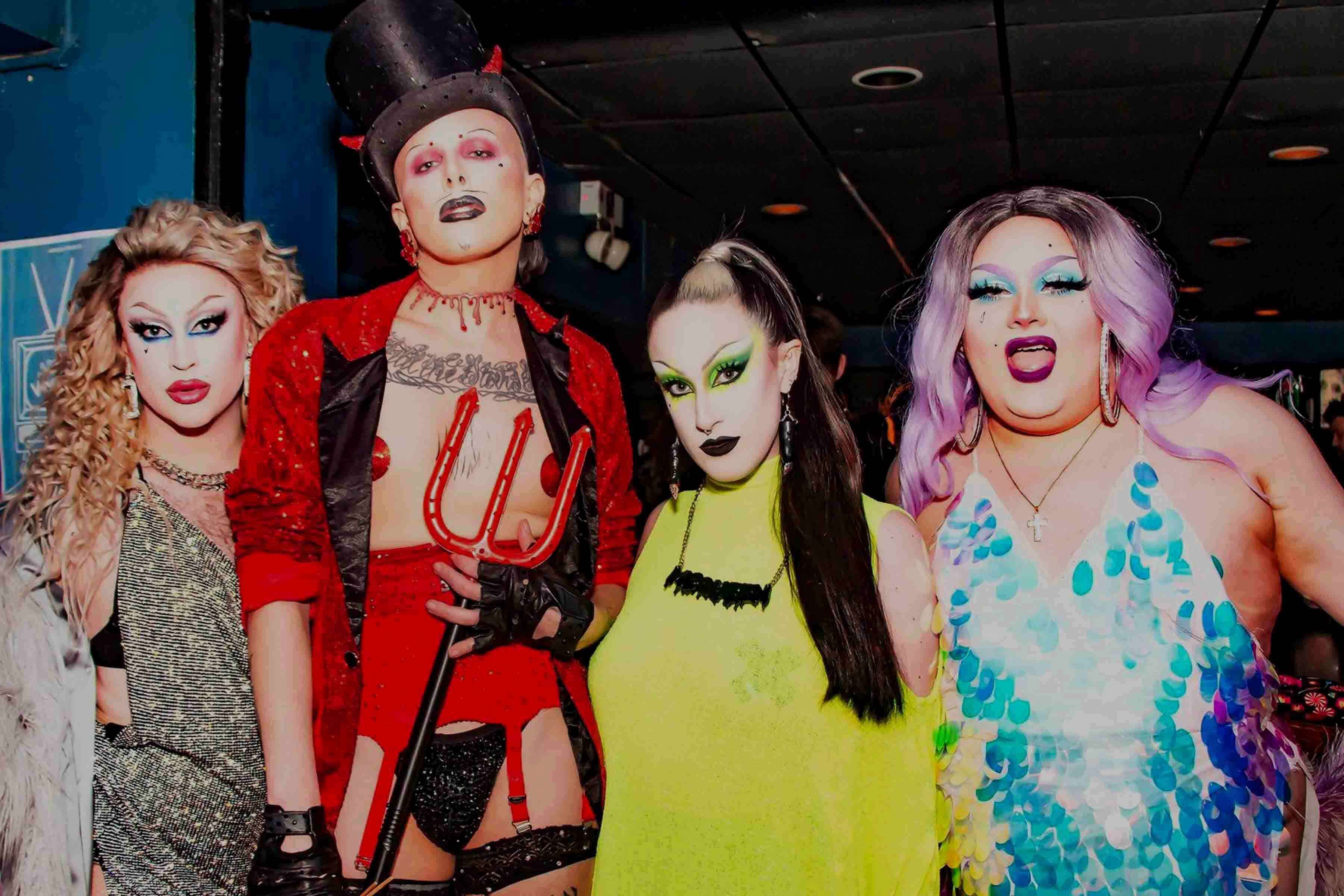 Four young people wearing make-up and dressed in costumes.