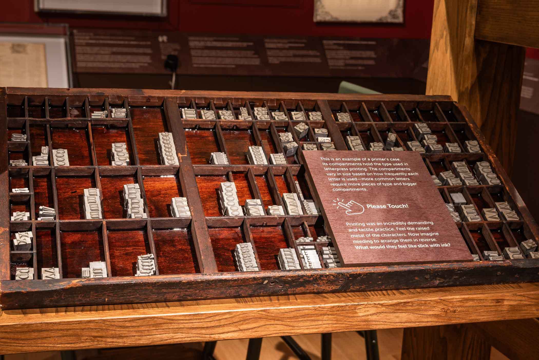 Wooden printer’s type case filled with metal letterpress type on display.
