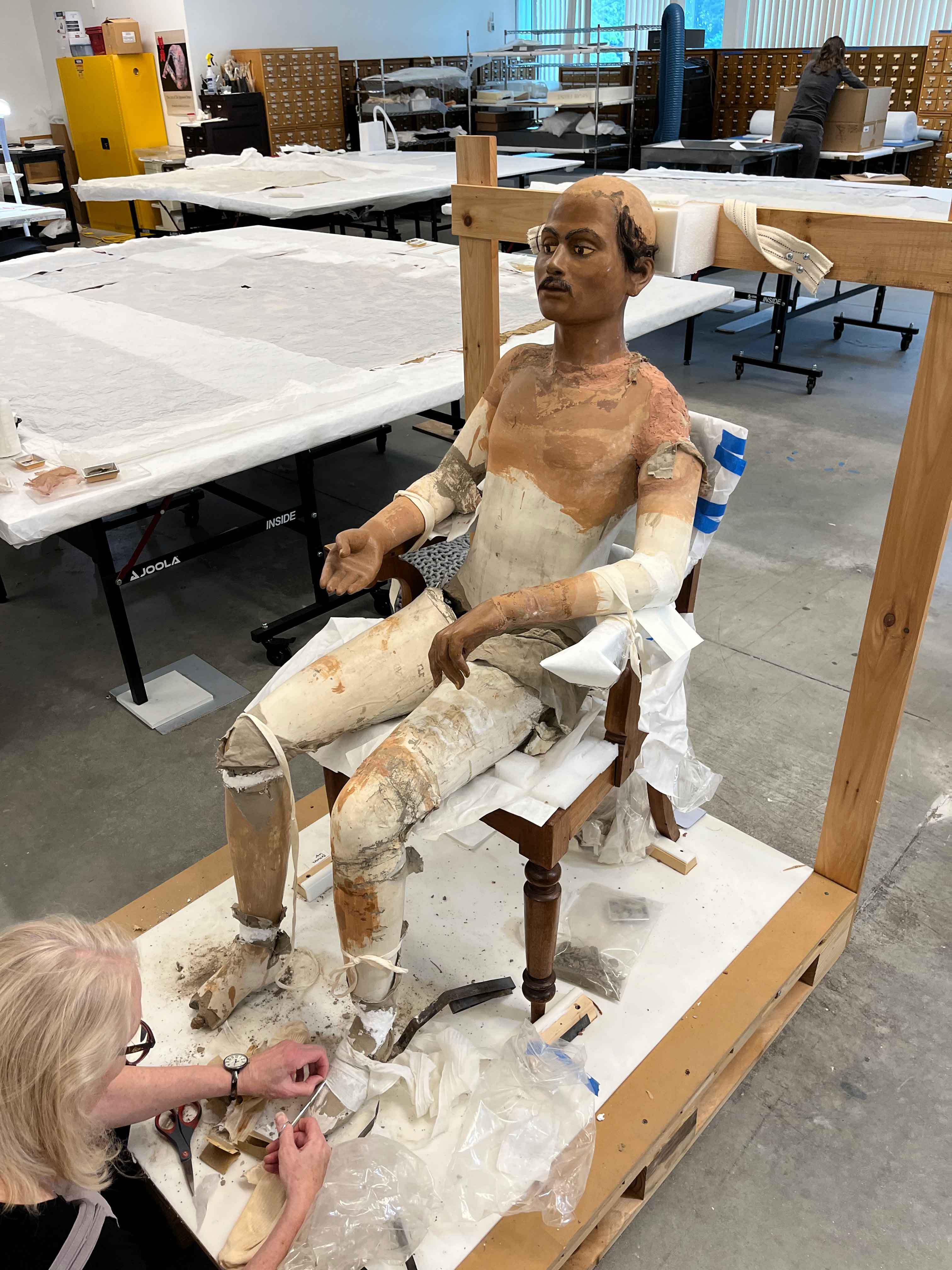 Conservator Mimi Levesque works with the life-size sculpture. Photo by Tristan R. Latham/PEM.