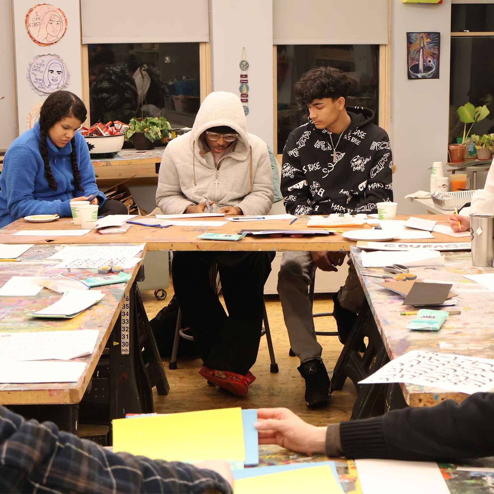 Students making collagraph printmaking plates.