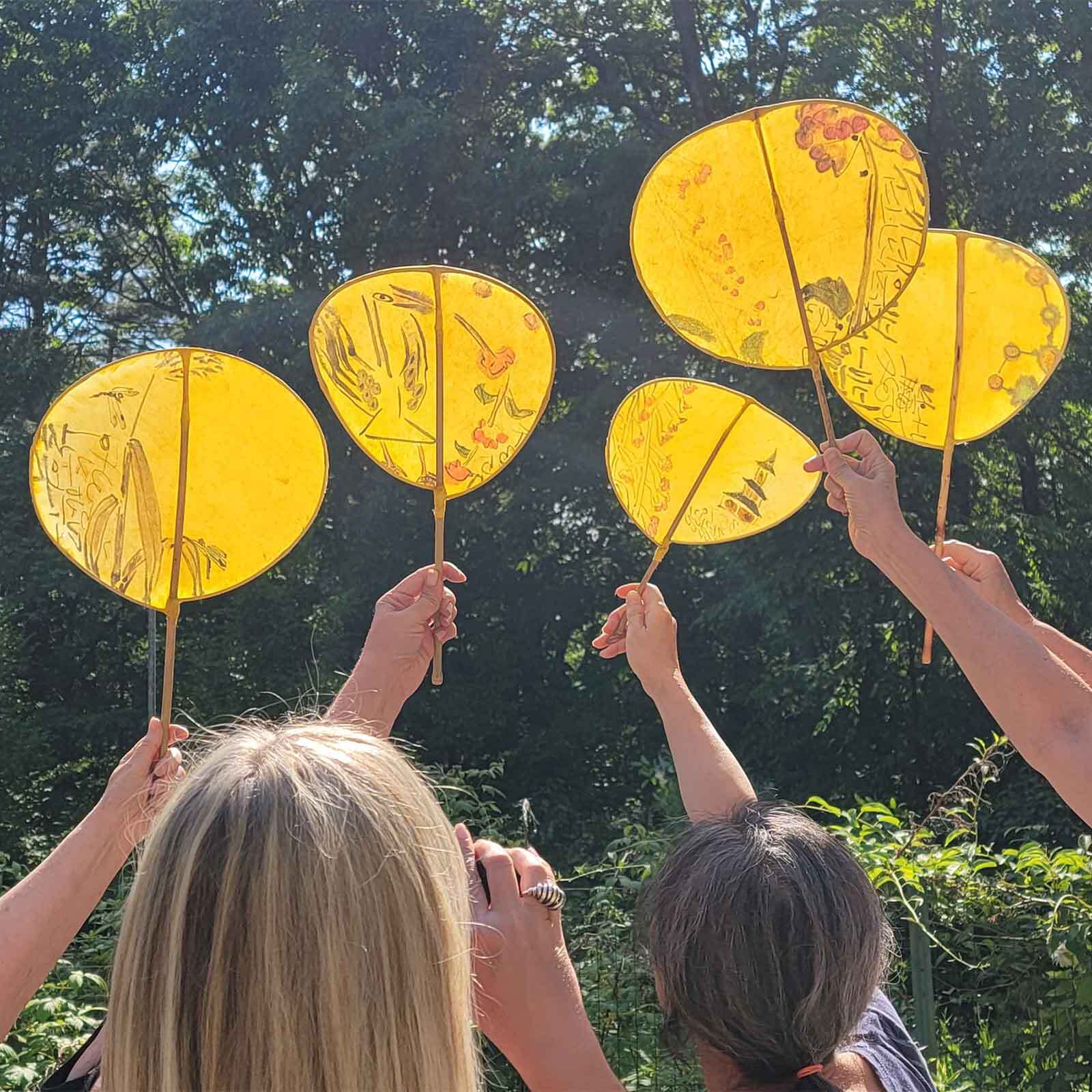 Workshop guests lift up Korean paper accessories