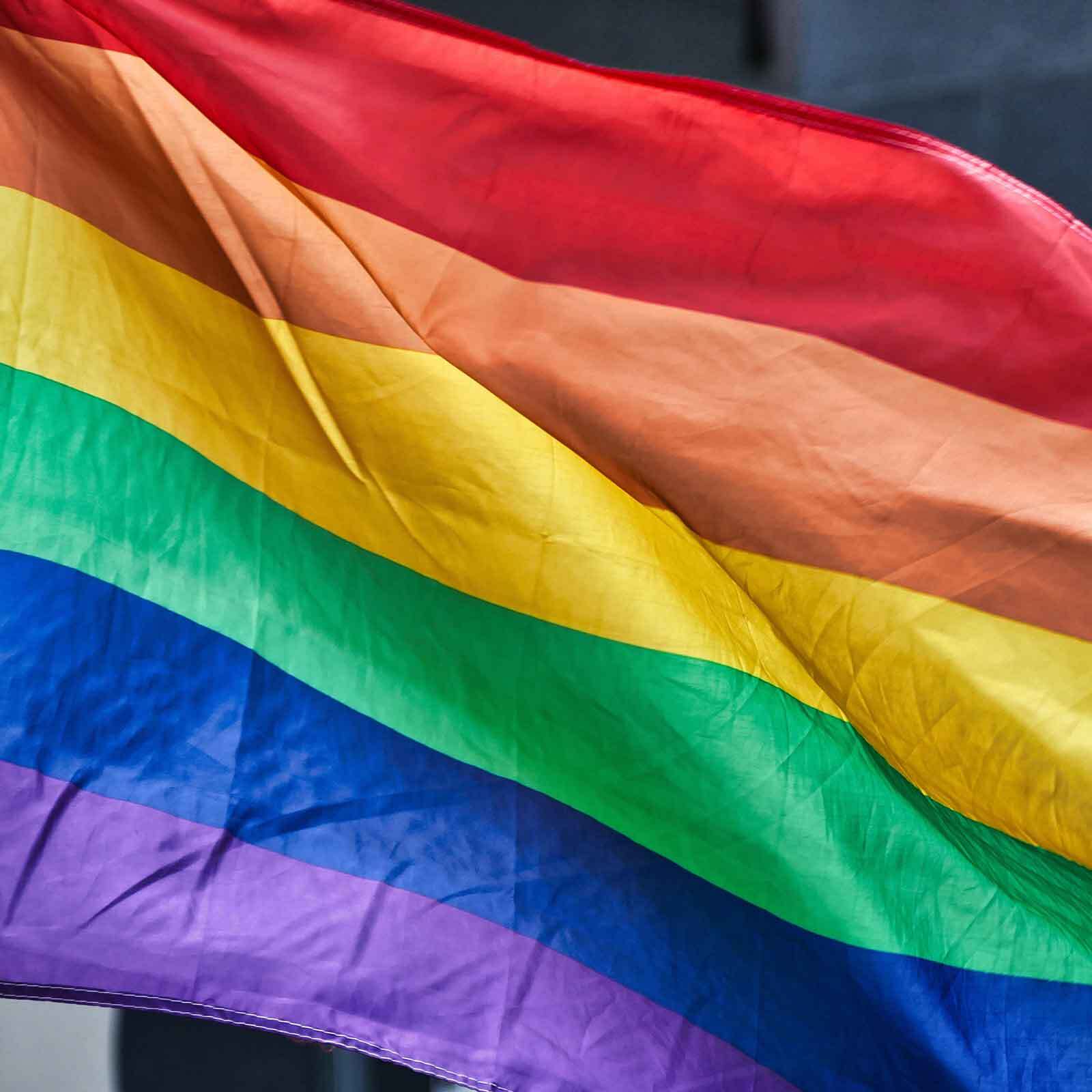 A vibrant rainbow pride flag fluttering in the wind