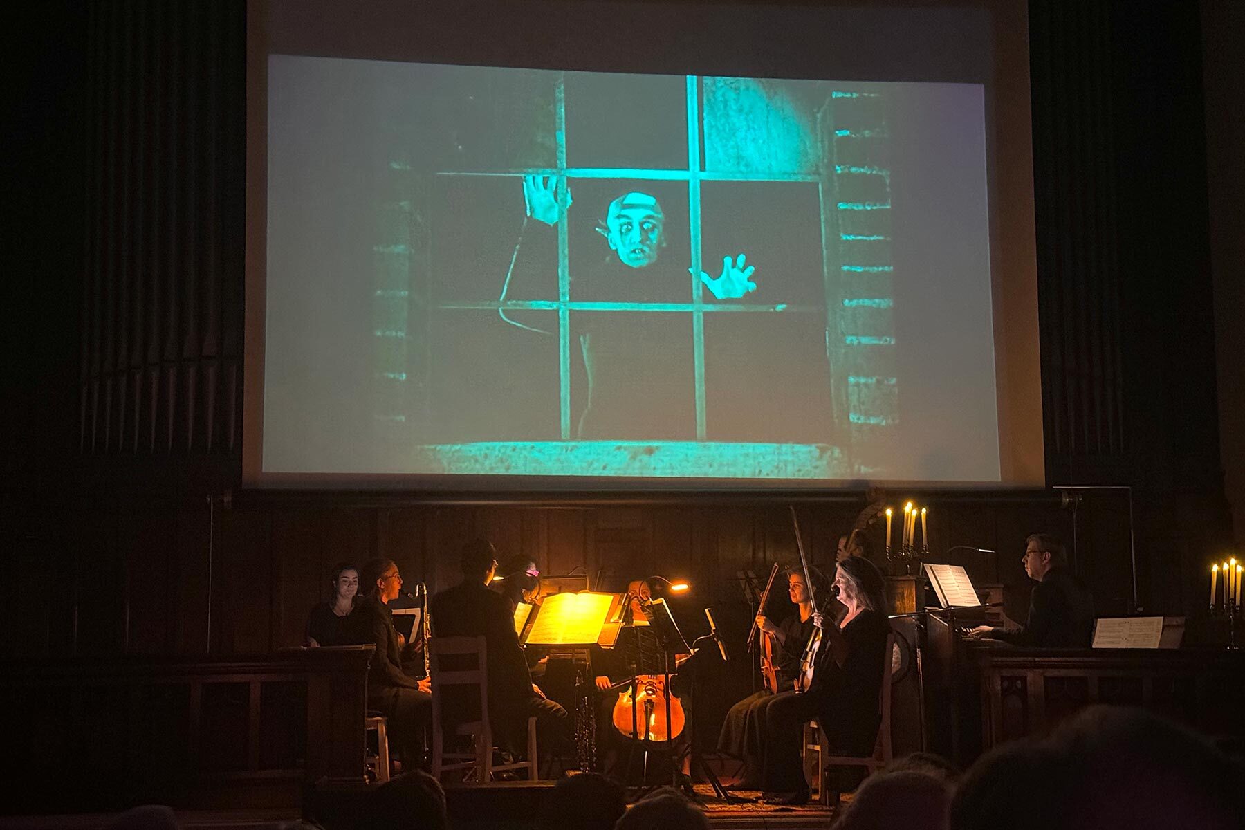 Orchestra playing in front of a projected film image of Nosferatu