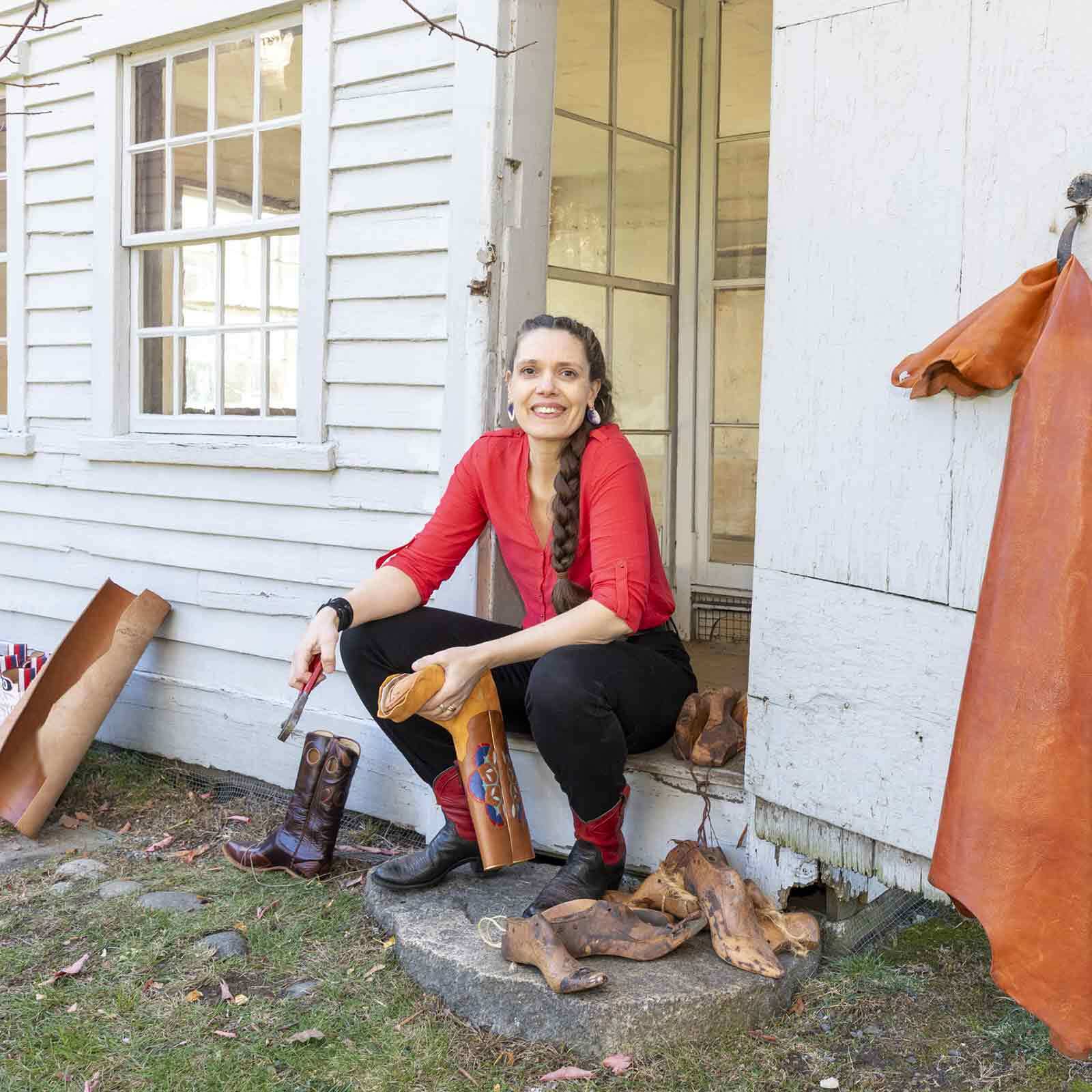 Sarah Guerin sitting on the doorstep to Tapley-Lye Ten Footer Shoe Shop