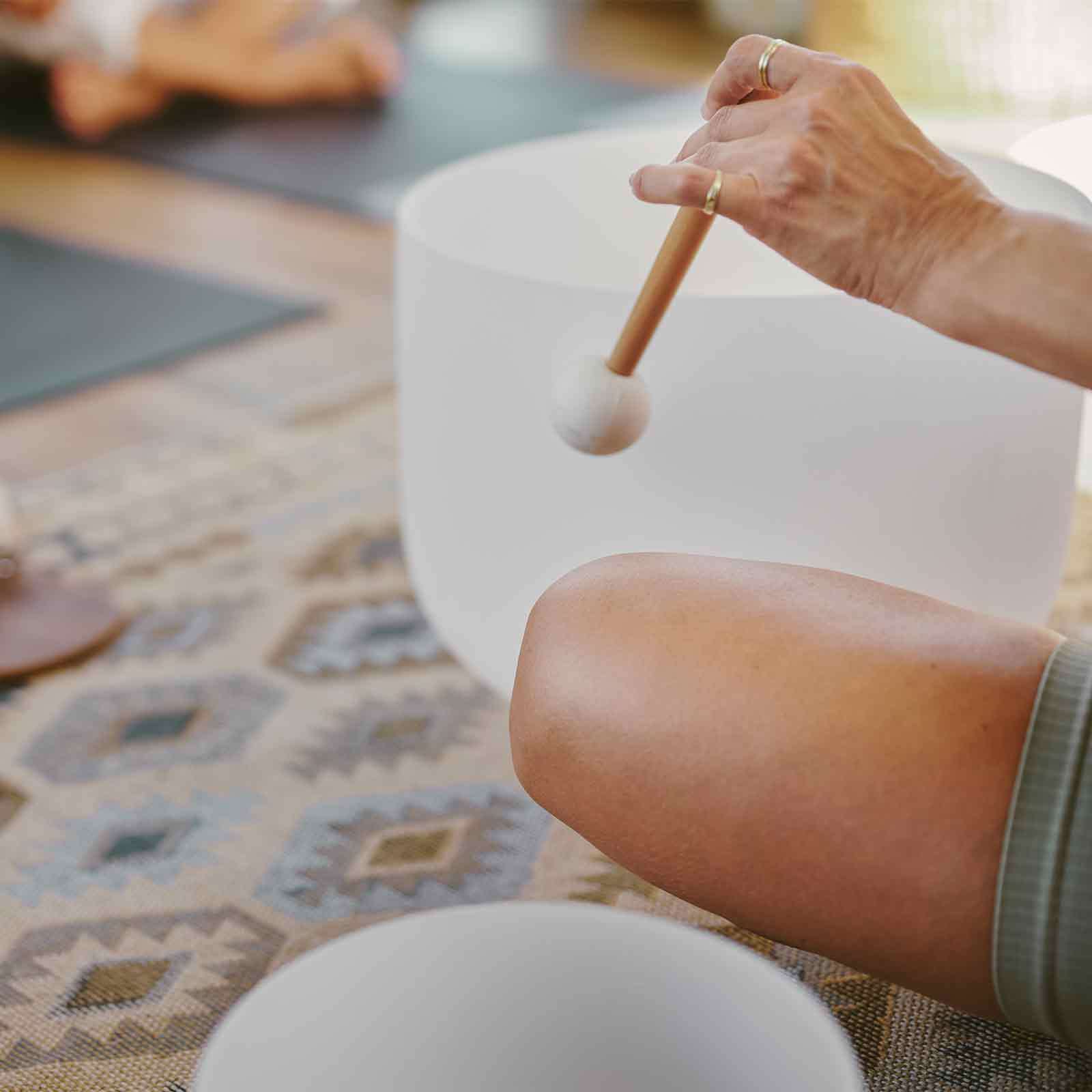 An instrument waves over the edge of a bowl to elicit a melodic sound