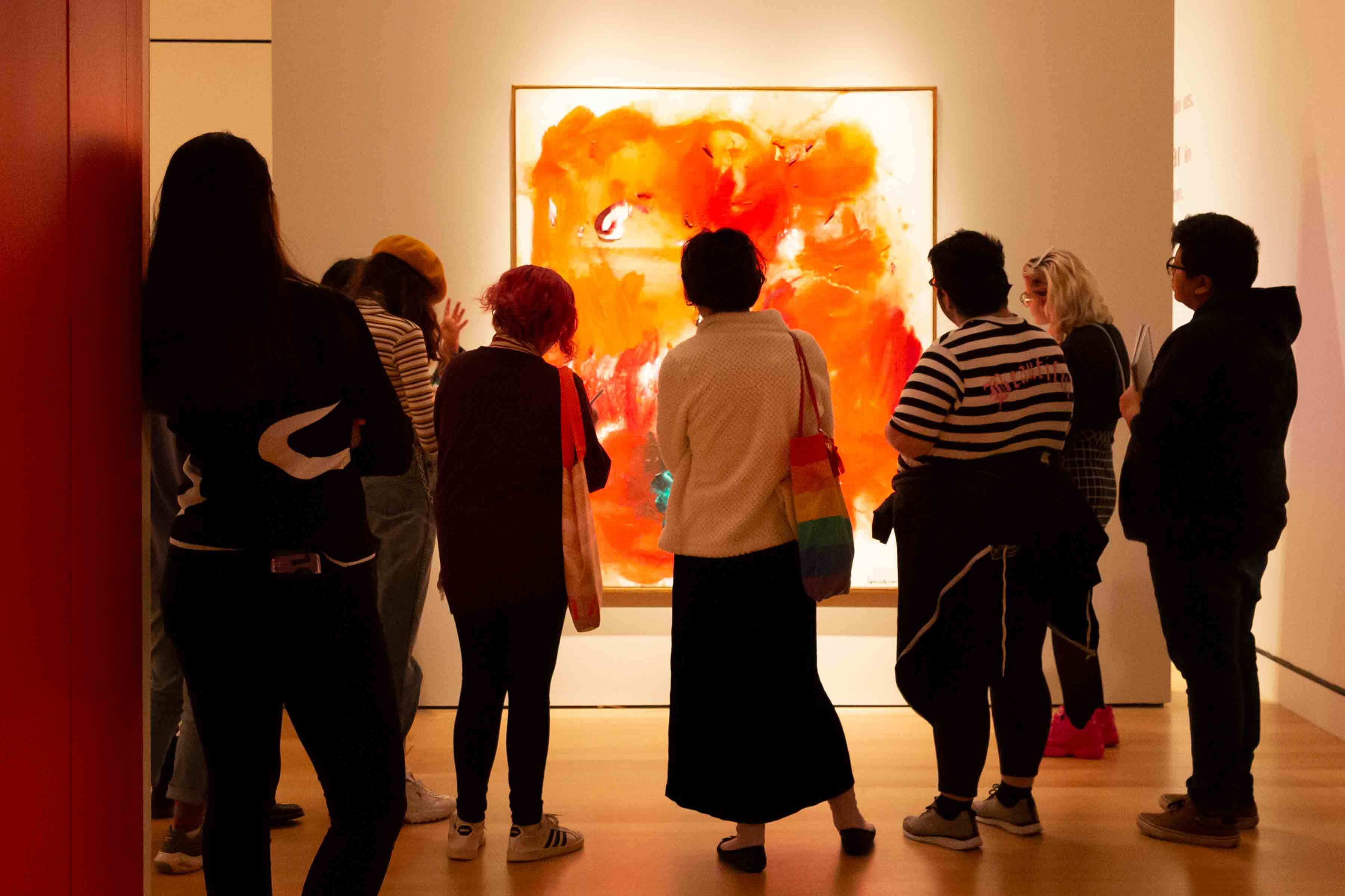 A group of visitors in a gallery looking at a large modern painting by Hans Hoffmann.