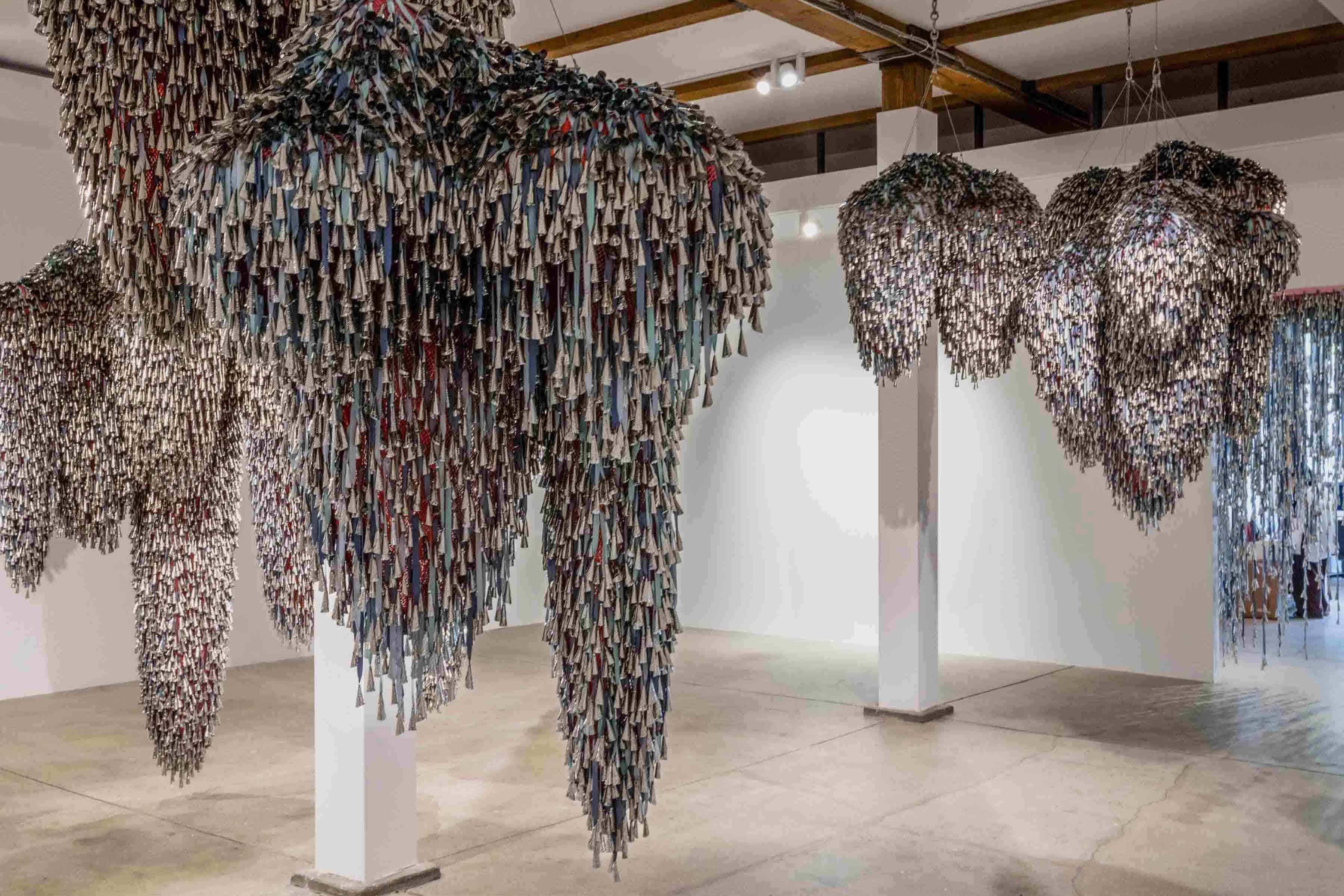 Marie Watt's work hanging from the ceiling in a gallery