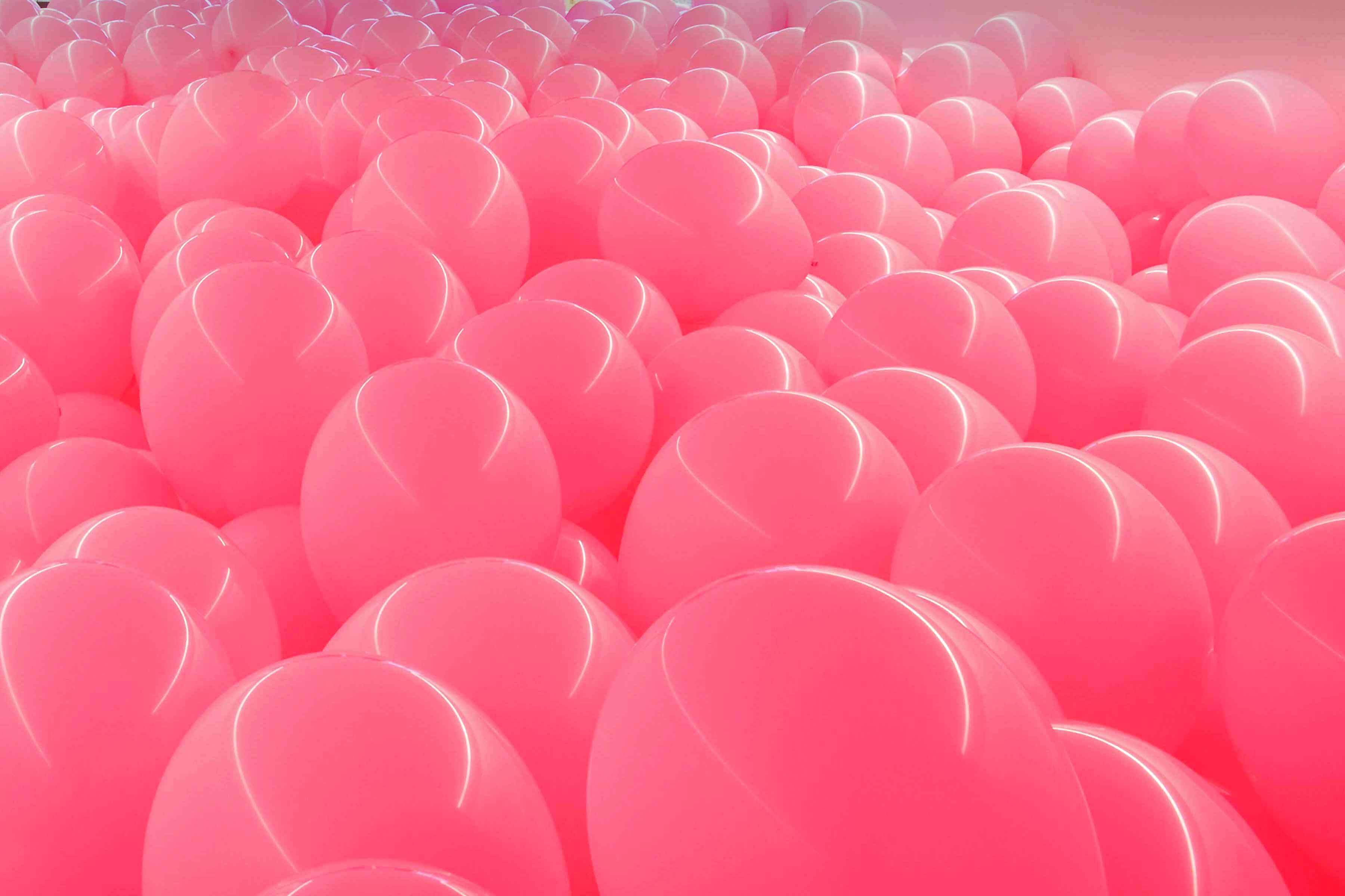 Pink balloons fill a room