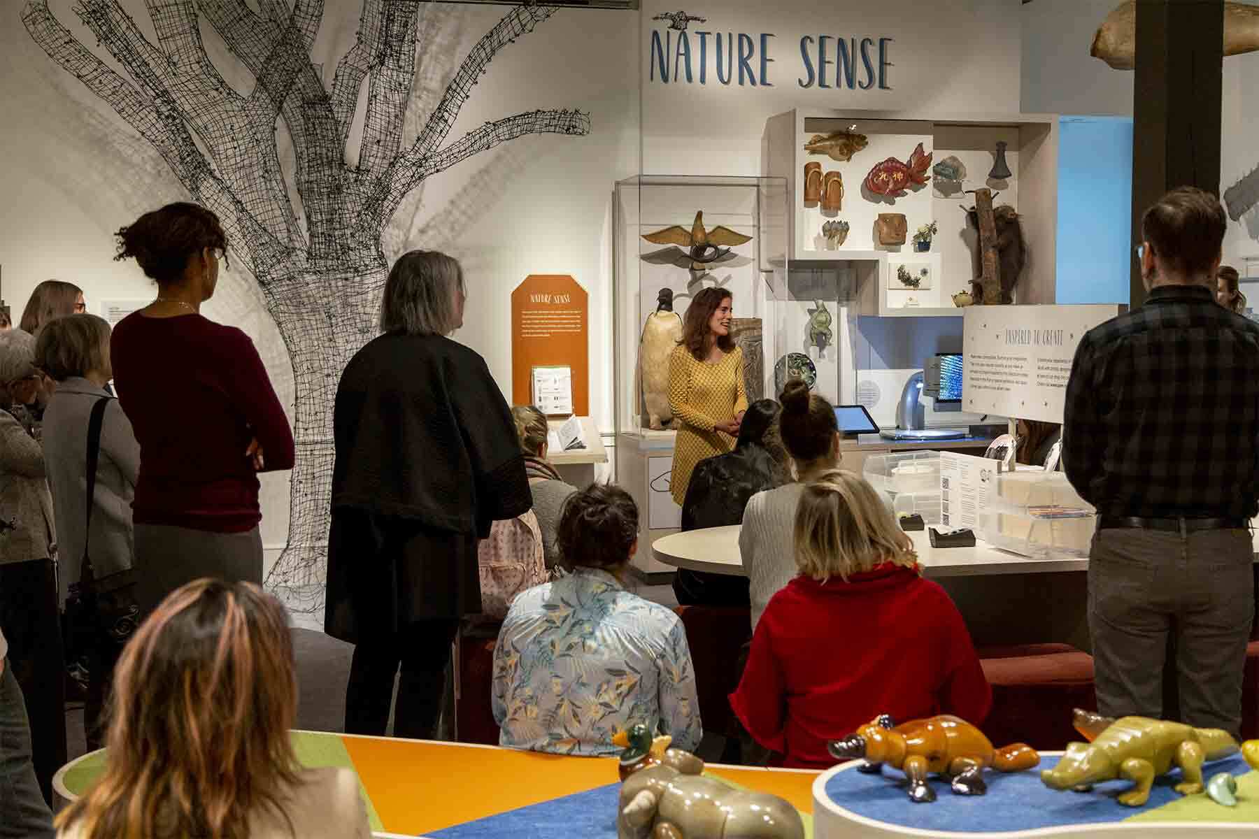 People listening to the curator during a tour of the Pod