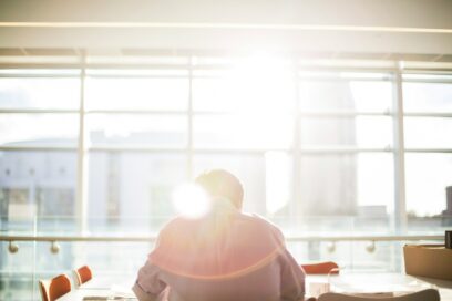 a man sitting at a desk with a ray of light