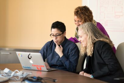 Three people looking at a computer together