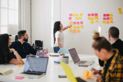 Woman placing sticky notes on wall in a DEI assessment meeting