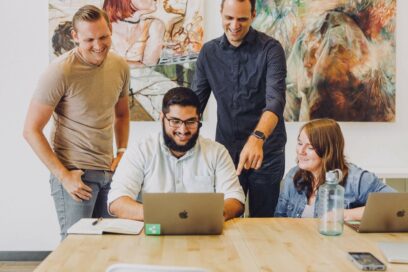 a group of people in front of a laptop having a meeting