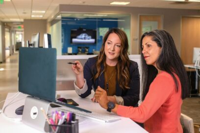 two women looking at a computer screen going over employer brand strategy