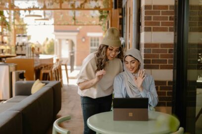 Two women in front of a laptop discusssing DEI strategy