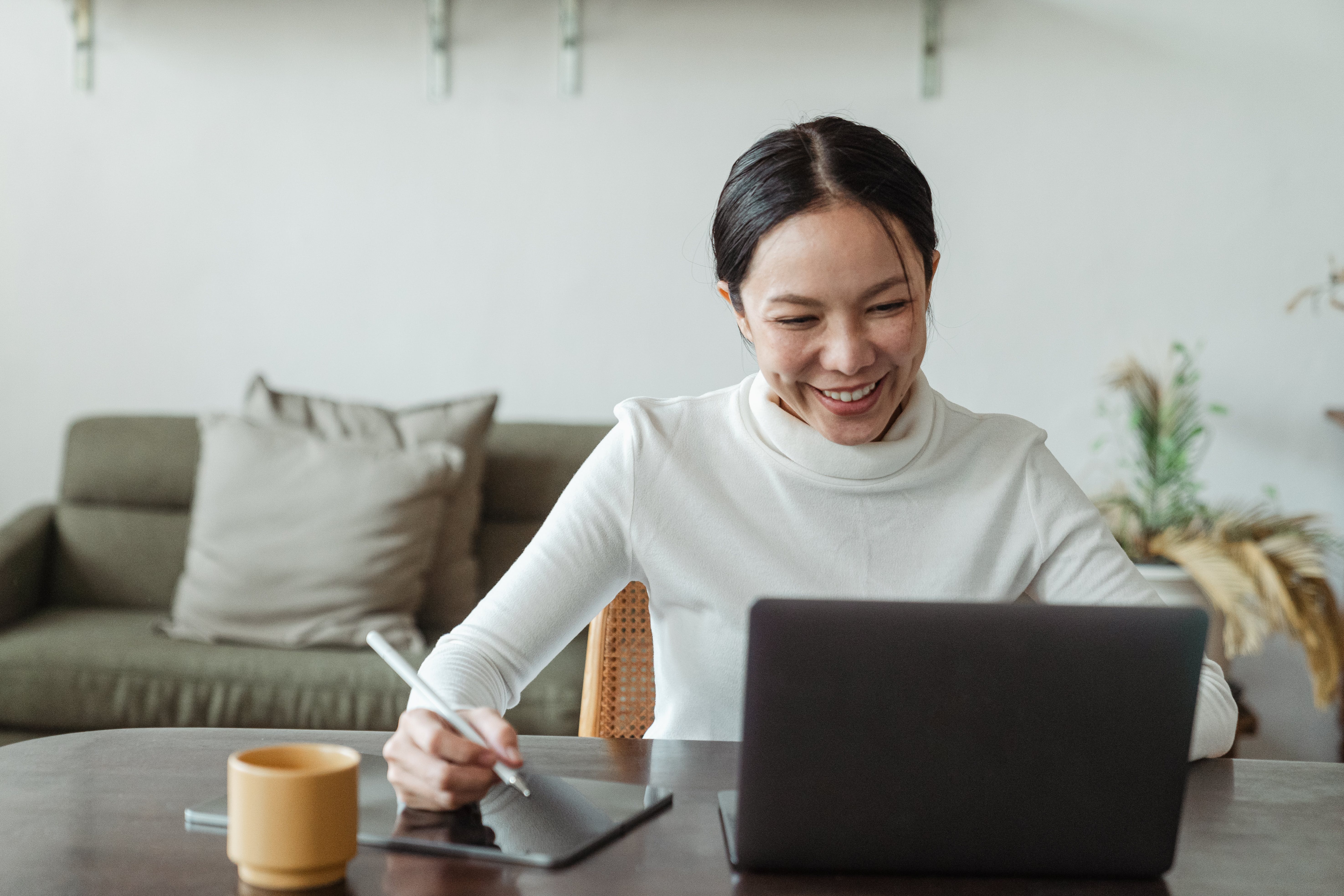 A woman looking at her laptop working from home