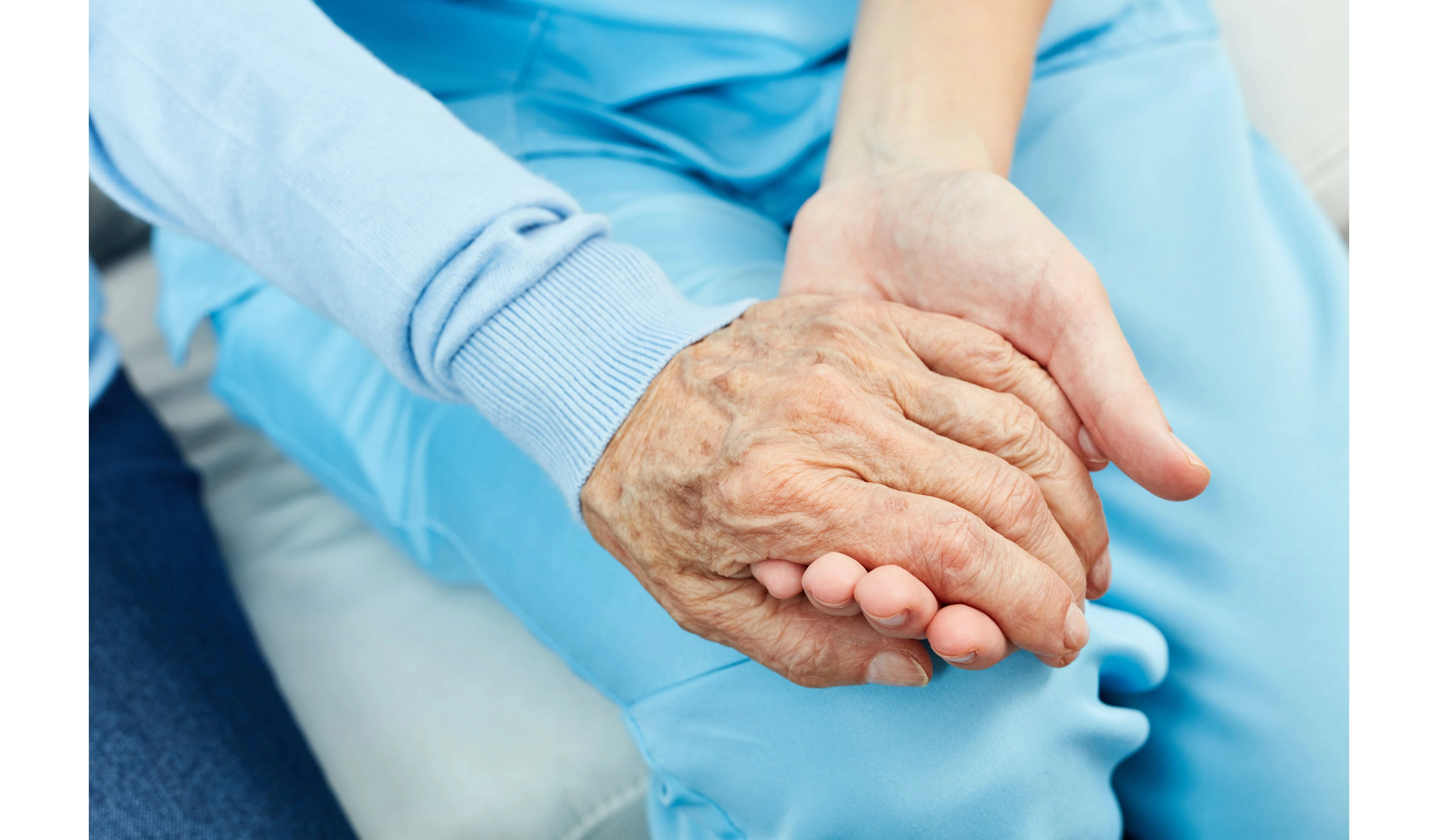 a female house cleaner holding hands of a senior citizen