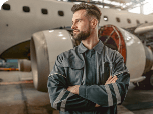 Empresário de braços cruzados com avião ao fundo