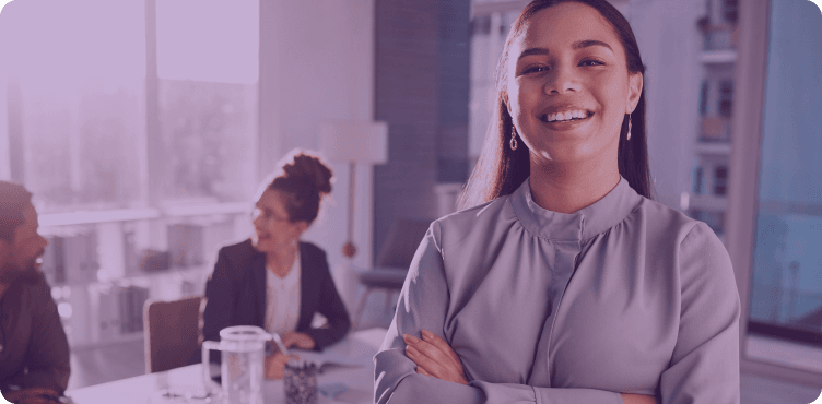 Profissional de RH sorridente no escritório, com colegas trabalhando ao fundo