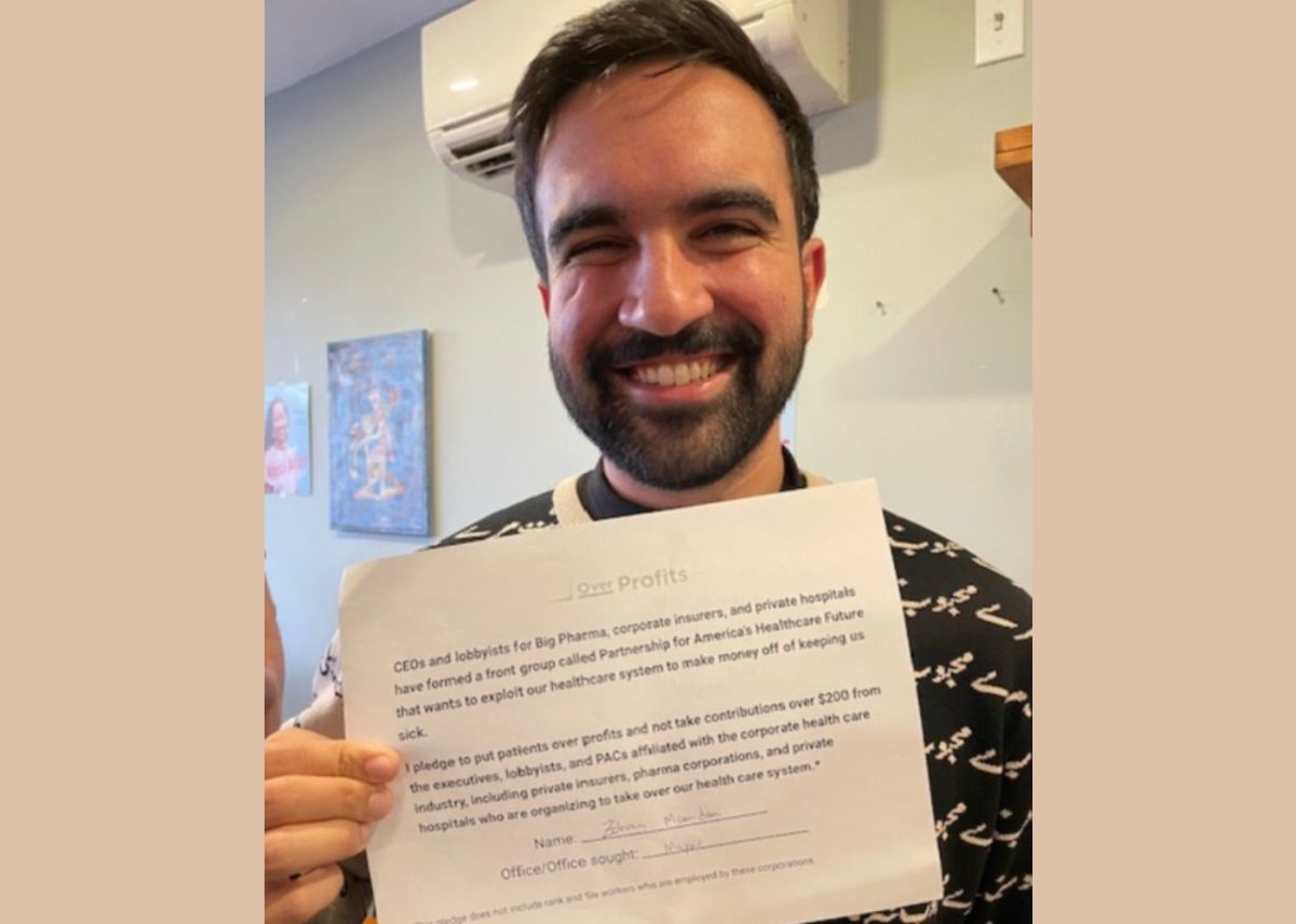 Photo of Zohran Mamdani holding the Patients Over Profits pledge