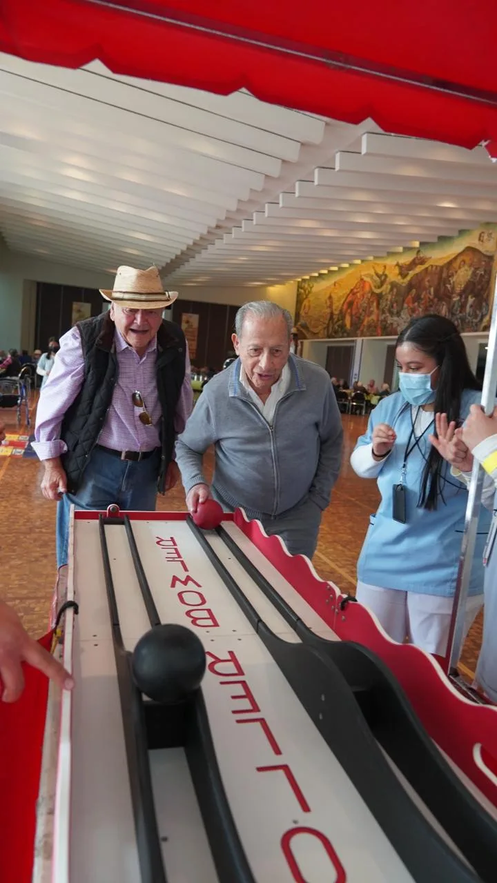 Adultos mayores jugando boliche de feria en un evento