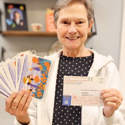 A MomsRising volunteer with handwritten postcards