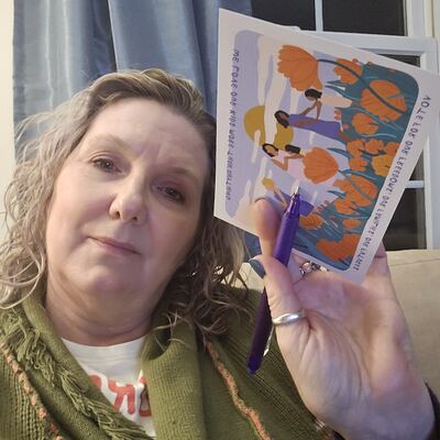 A MomsRising volunteer with handwritten postcards