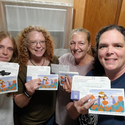 A MomsRising volunteer with handwritten postcards