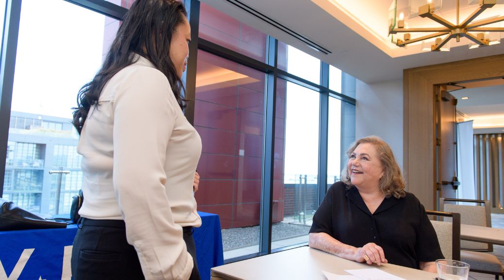 Image of Kathleen Turner speaking to an attendee of the Young Elected Officials Network annual convening.
