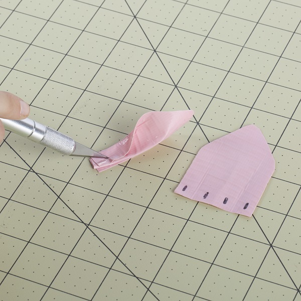 Rectangular hole cut into each fold of the previously made piece